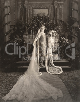 Bride wearing medieval gown standing at altar