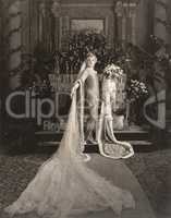 Bride wearing medieval gown standing at altar