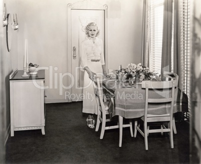 Woman standing by beautifully set dining room table
