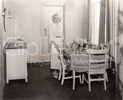 Woman standing by beautifully set dining room table