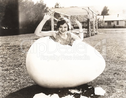 Woman popping out of giant egg