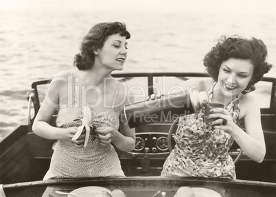 Two women having a snack on motorboat