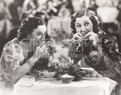 Two women distracted from their meal