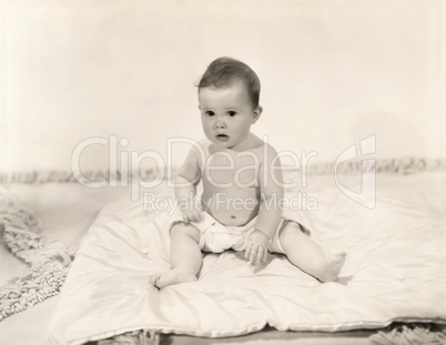 Portrait of baby girl sitting on blanket