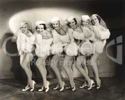 Line of chorus girls in white fur