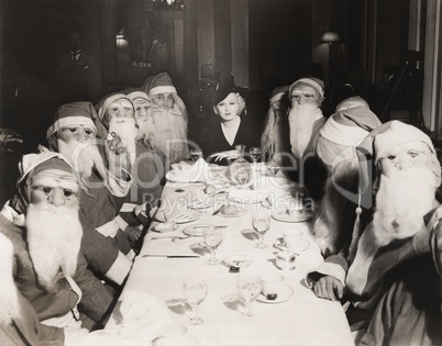 Woman lunching with twelve Santa Clauses