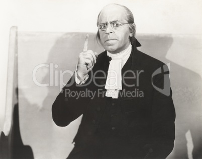 Man in square wire rim glasses making a point