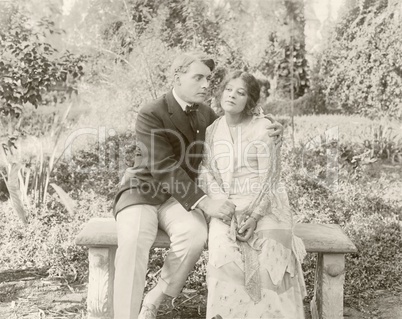 Loving couple sitting on bench in park