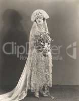 Bride wearing ruffled wedding gown and flowered headdress