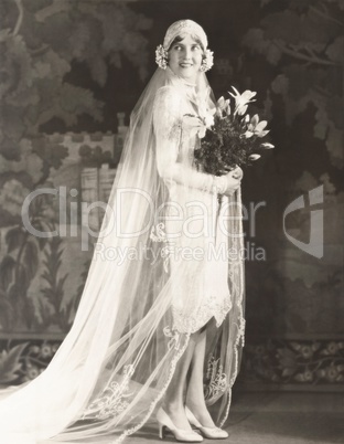 Bride carrying bouquet of lilies