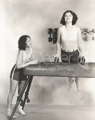 Gymnasts taking turns on pommel horse