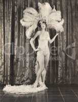 Showgirl wearing feather headdress and sequined bikini