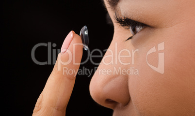 Closeup of woman putting contact lenses