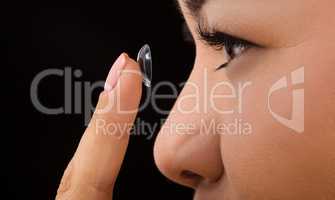 Closeup of woman putting contact lenses