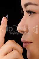 Closeup of woman putting contact lenses