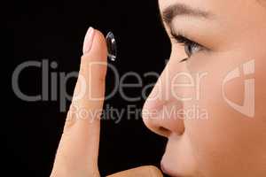 Closeup of woman putting contact lenses