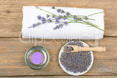 lavender flowers, aromatic candles, and towels on wooden backgro