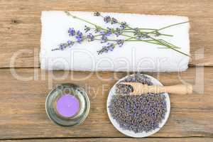 lavender flowers, aromatic candles, and towels on wooden backgro