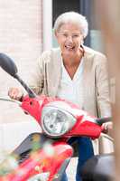 Seniorin auf Motorroller