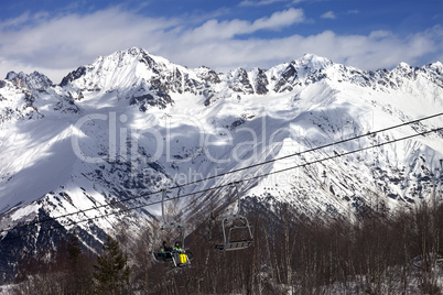 Skiers on ski-lift at winter sun day