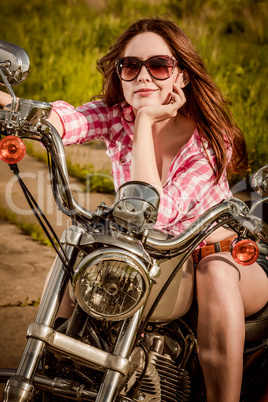 Biker girl sitting on motorcycle