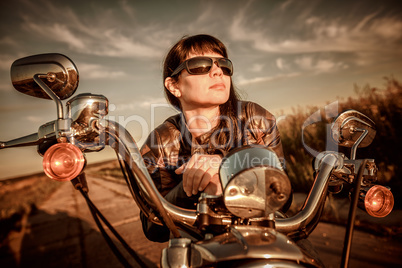 Biker girl sitting on motorcycle