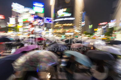 Motion Blurred People in Rain on Shibuya Crossing, Tokyo, Japan