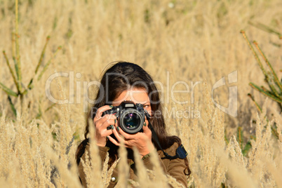 Nature photographer girl in yellow field