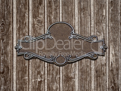 Vintage cast metal plate on old wooden texture close-up