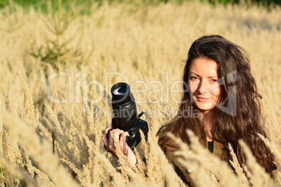 Girl nature photographer waiting in autumn meadow