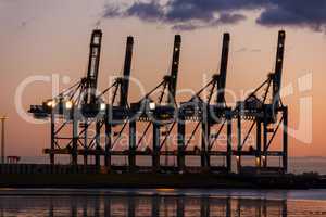 Sunset or Sunrise Behind Cranes at Container Port