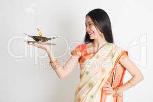 Girl with Indian sari dress holding oil lamp