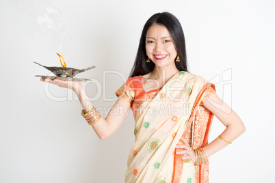 Girl with Indian sari dress holding oil lamp diya