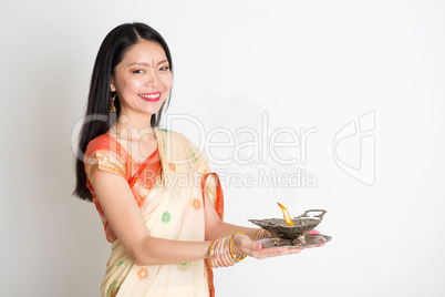 Woman with Indian sari dress holding oil lamp