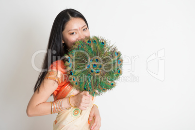 Female with peacock feather fan in Indian sari dress