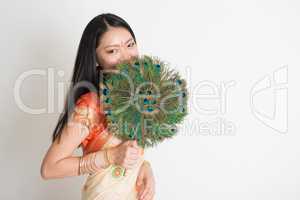 Female with peacock feather fan in Indian sari dress