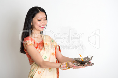 Female with Indian sari dress holding oil lamp