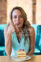 Smiling woman eating dessert in cafe