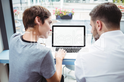 Businesspeople discussing over laptop