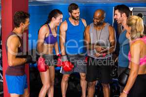 Smiling coach discussing with boxers