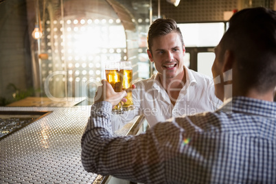 Two men toasting a glass of beer