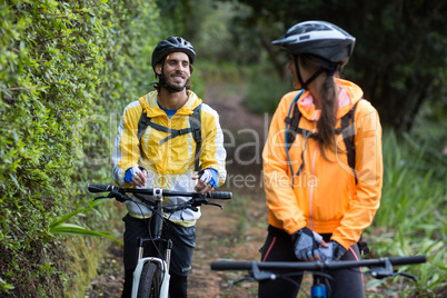 Biker couple interacting while cycling in countryside