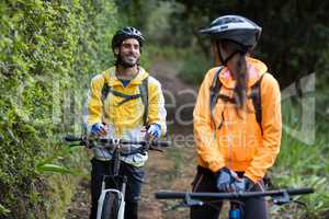 Biker couple interacting while cycling in countryside