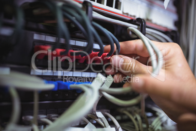 Technician plugging patch cable in a rack mounted server
