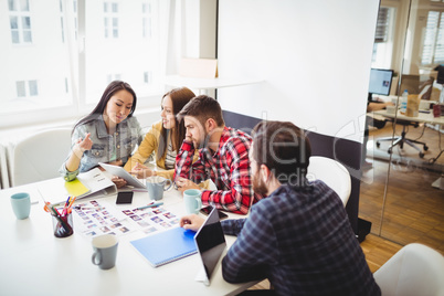 Photo editors using digital tablet in meeting room