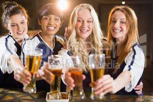 Group of friends holding glass of beer in party
