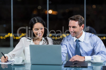 Businessman discussing with colleague over laptop