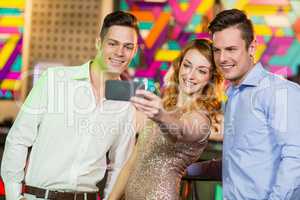 Smiling friends taking a selfie from mobile phone
