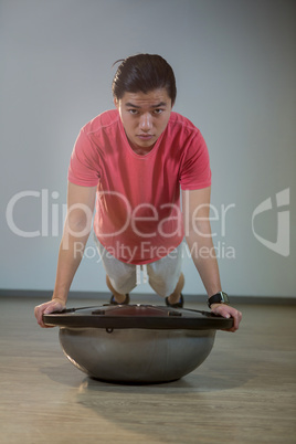 Man doing push-up on bosuball