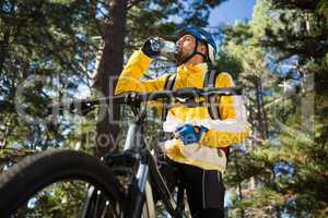 Male mountain biker drinking water